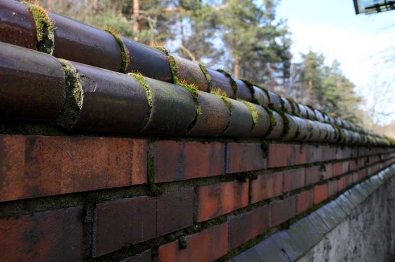 Mur wykonany z cegieł i kształtek klinkierowych glazurowanych w odcieniach brązu