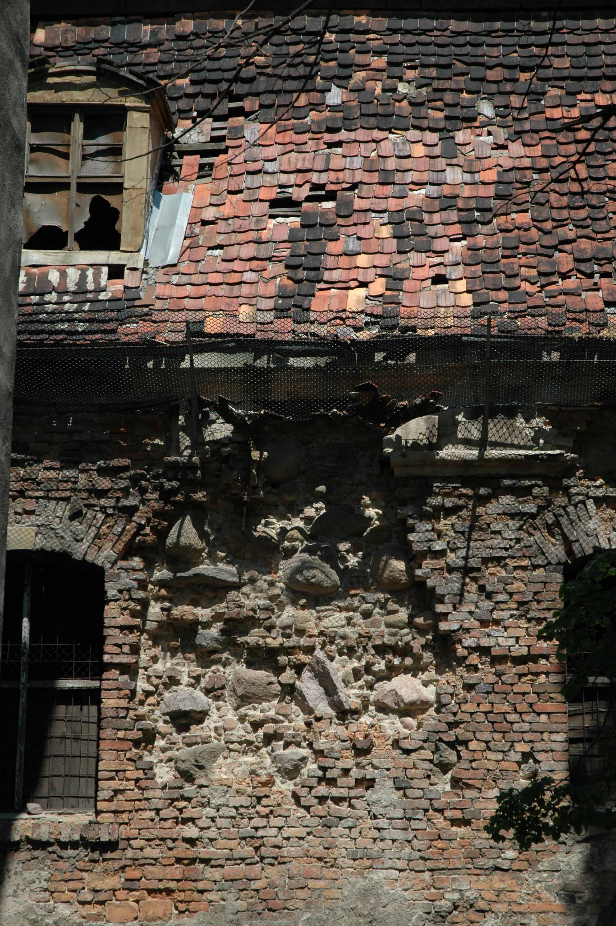 Zabytkowa budowla (w ruinie) z cegły gotyckiej oraz bloków kamiennych
