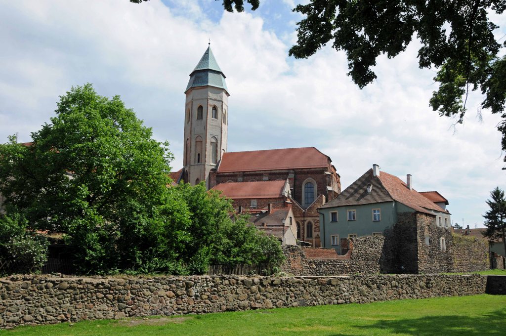 Średniowieczne mury obronne zbudowane z kamienia i cegły gotyckiej
