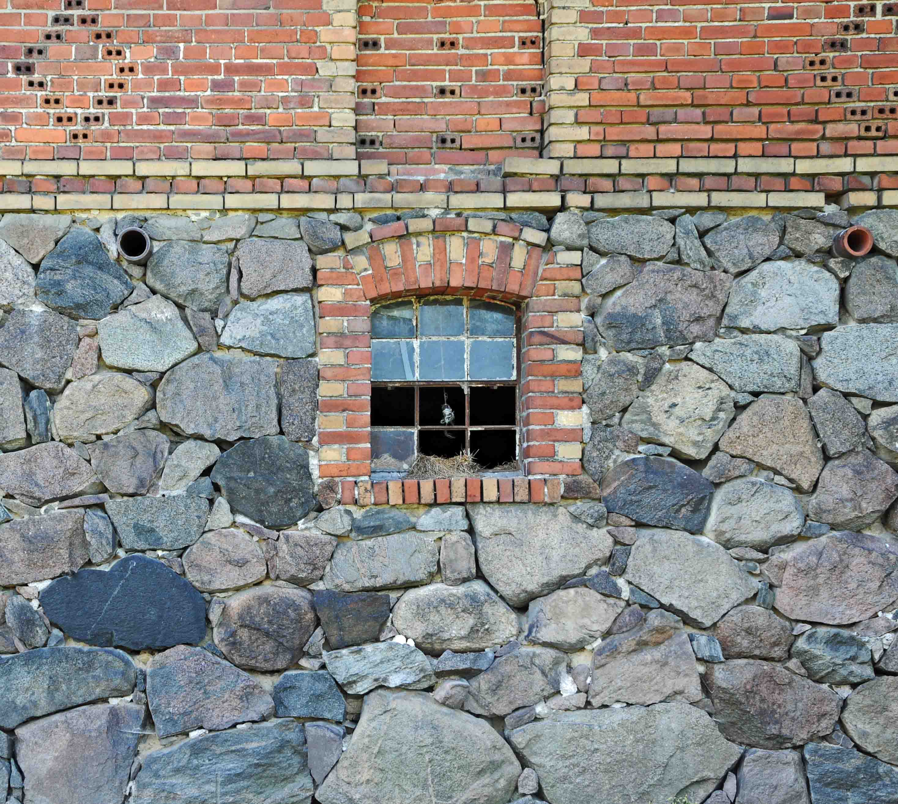Mur z cegły i kamienia stajni z przełomu XVIII i XIX w.,  kładziony na glinie fugowany zaprawą wapienną. Przed renowacją