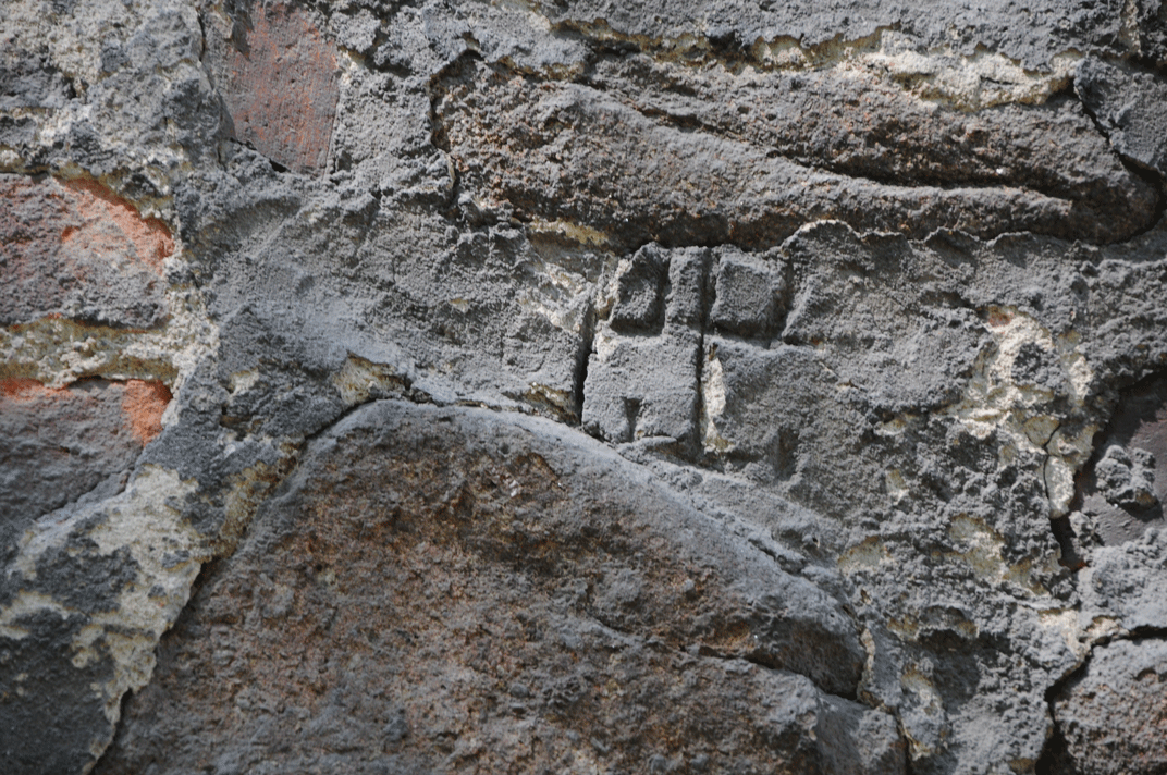 Sygnatura murarska w spoinie wapiennej, w starym murze średniowiecznym
